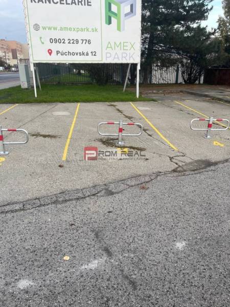 Parking spaces with blockers on Púchovská Street, Bratislava III in front of garages.