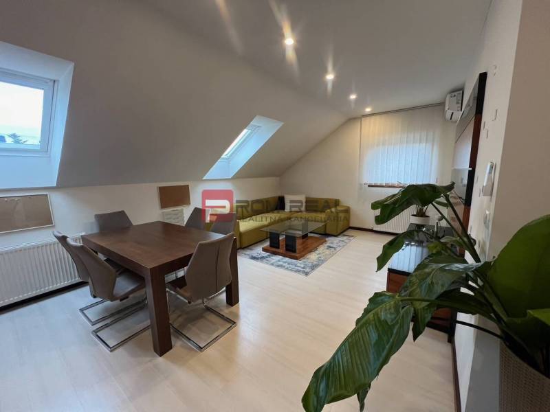 Interior of a production space with a dining table, chairs, and a plant in the corner of the room.