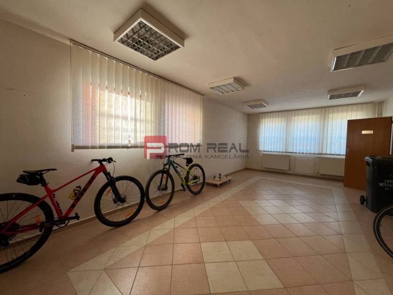 Interior of production facilities with bicycles, tiles, and windows with blinds.