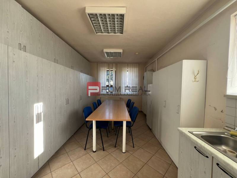 Interior of a production space with a long table and cabinets, simple equipment.