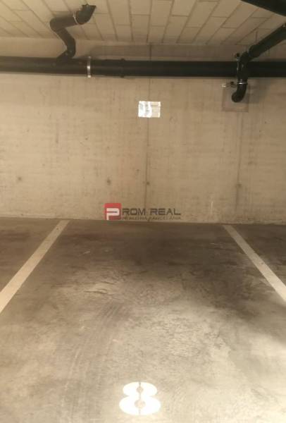 A parking space in garages with a pipe on the wall.