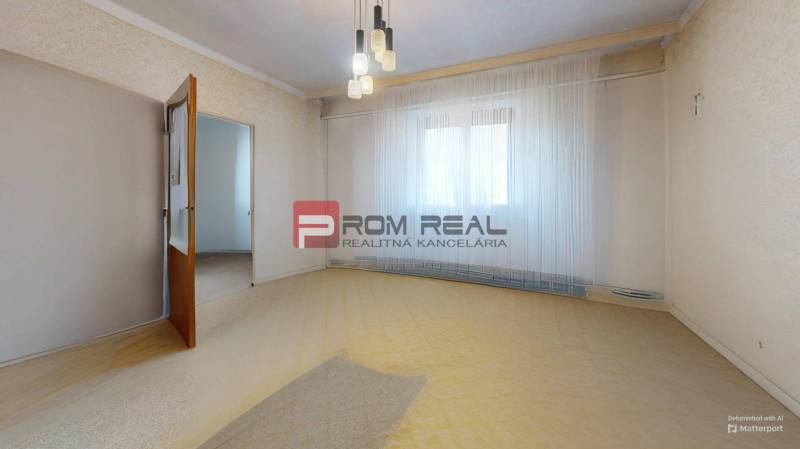 A room in a family house with open wooden doors, curtains, and chandeliers.