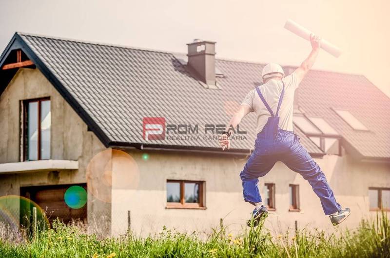 A builder happily jumps in front of the house, holding construction plans. Construction and a 1-bedroom apartment.