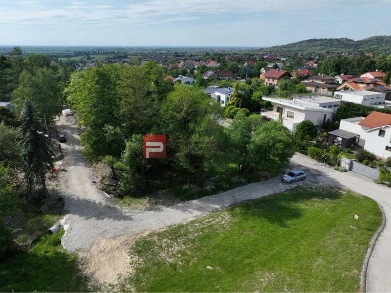 Plots - housing in Marianka on Na tálkoch street, surrounded by greenery and houses.