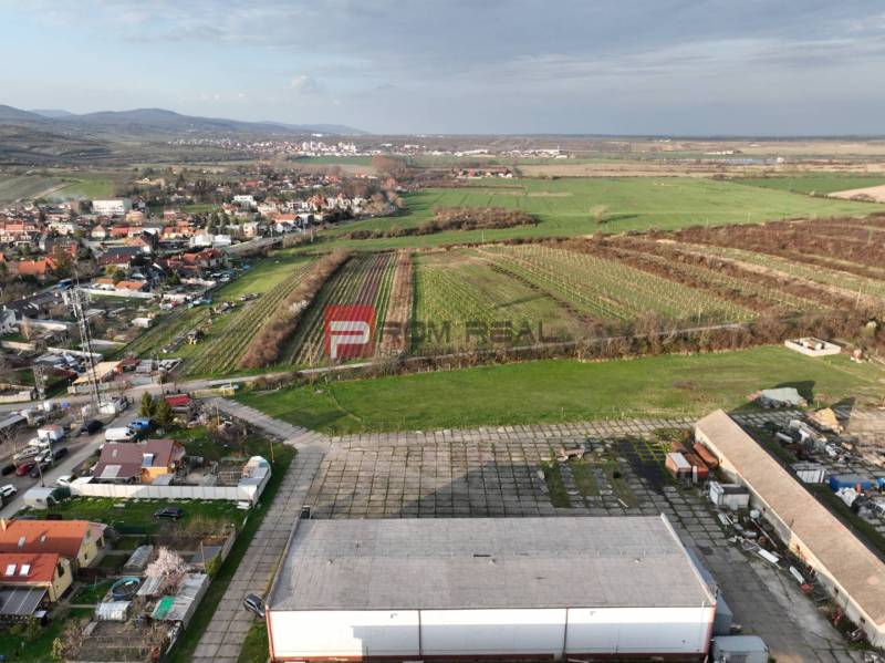 Aerial view of Vinosady from Pezinok Street, surrounded by vineyards and production facilities.