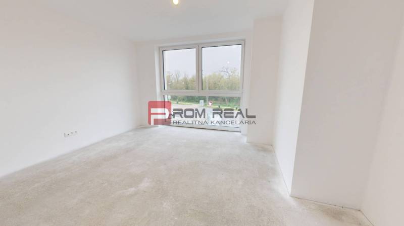 An empty room with a large window in a family house, waiting to be furnished.