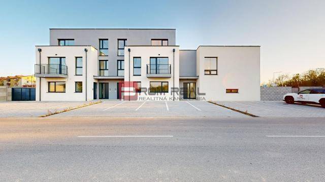 Building on Bottova Street, modern architecture, parking lot, and family house in the background.