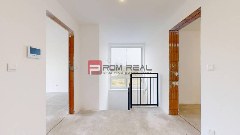 Interior of a family house with white walls, two doorways, and a window.