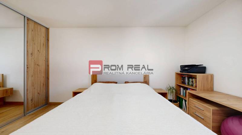 Bedroom in a 3-room apartment, wooden storage furniture elements, white walls.