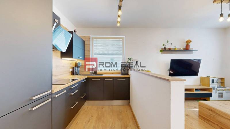 A kitchen in a 3-room apartment with a modern kitchen unit and a living area.