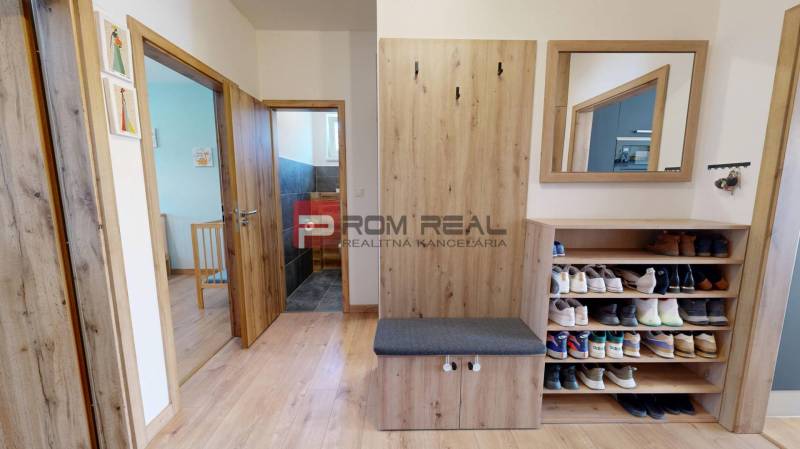 Entrance hall in a 3-room apartment with wooden accessories, a mirror, and a shoe cabinet.