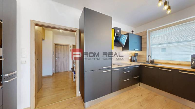 A kitchen in a 3-room apartment with wooden flooring and modern appliances.