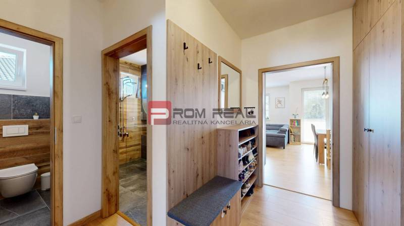 Hallway in a 3-room apartment with wooden details, entrance to the bathroom and living room.