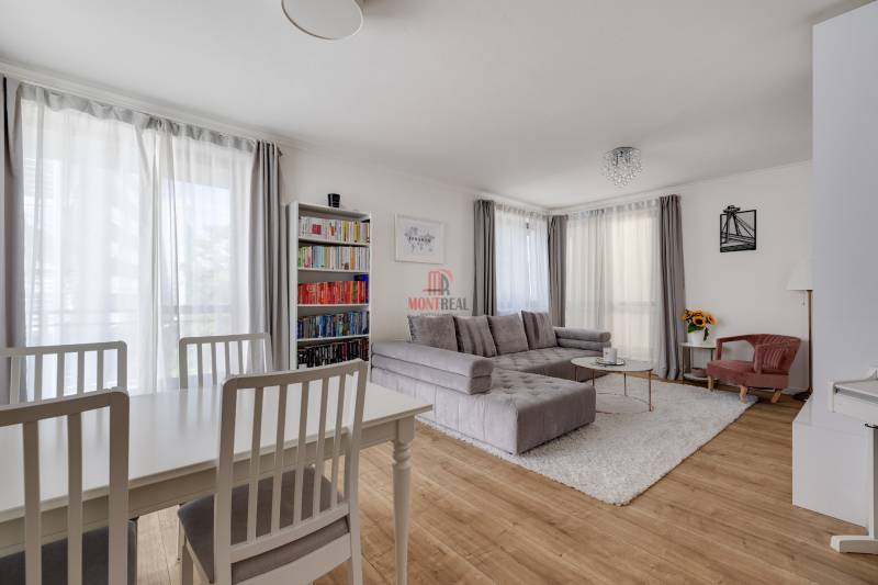 Living room with a sofa, dining table, and bookshelf in a 3-room apartment.