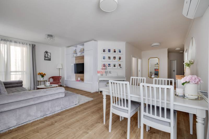 Bright living room with a dining table and a sofa in a 3-room apartment.