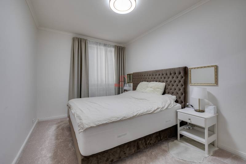 Bedroom in a 3-room apartment with a comfortable bed, a nightstand, and curtains.