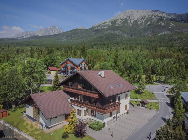 Recreational apartments in the High Tatras, surrounded by dense forest and majestic mountains.