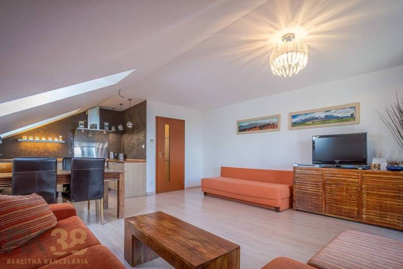 Living room of a holiday apartment with sofas, a dining table, and a television.