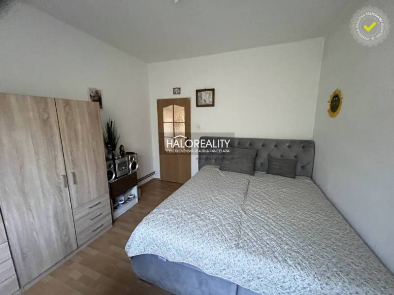 Bedroom in a 3-room apartment with a bed, wardrobe, and radio on a wooden floor.