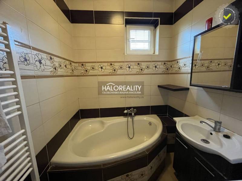 A bathroom with a corner bathtub and a sink in a renovated 3-room apartment.