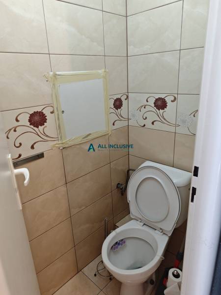A bathroom with tiles and a floral pattern in a 2-room apartment.