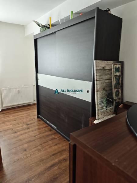 Sliding door wardrobe with decorations, wooden floor in a 2-room apartment.