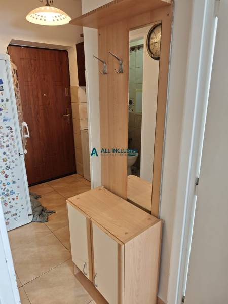 Entrance hall in a 2-room apartment with a wooden wardrobe and a mirror.