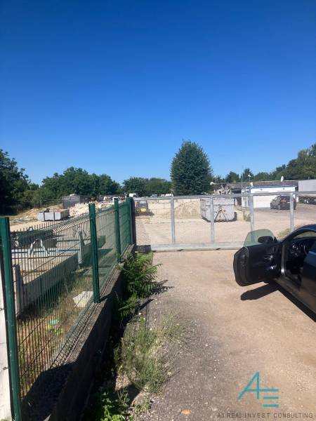 Commercial land on Popradská Street in Bratislava - Podunajské Biskupice with a car and a gate.