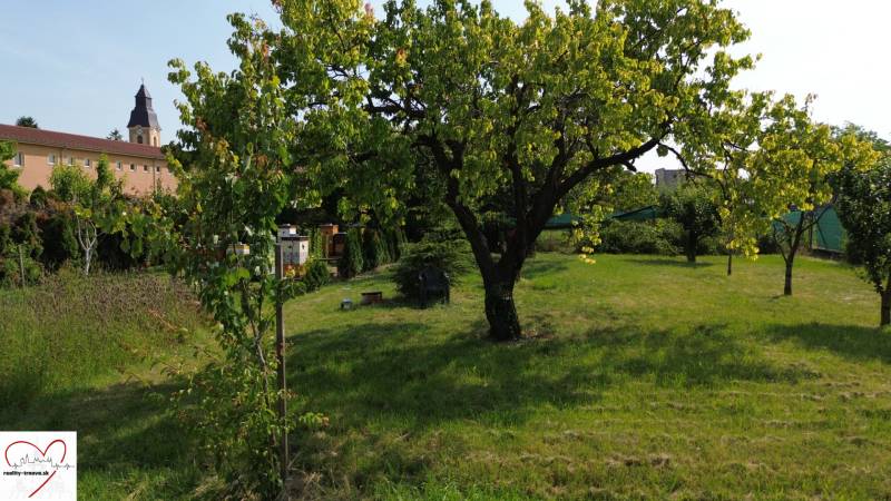 Greenery, trees, and a building in the background in Dolný Bar, Plots - residential.