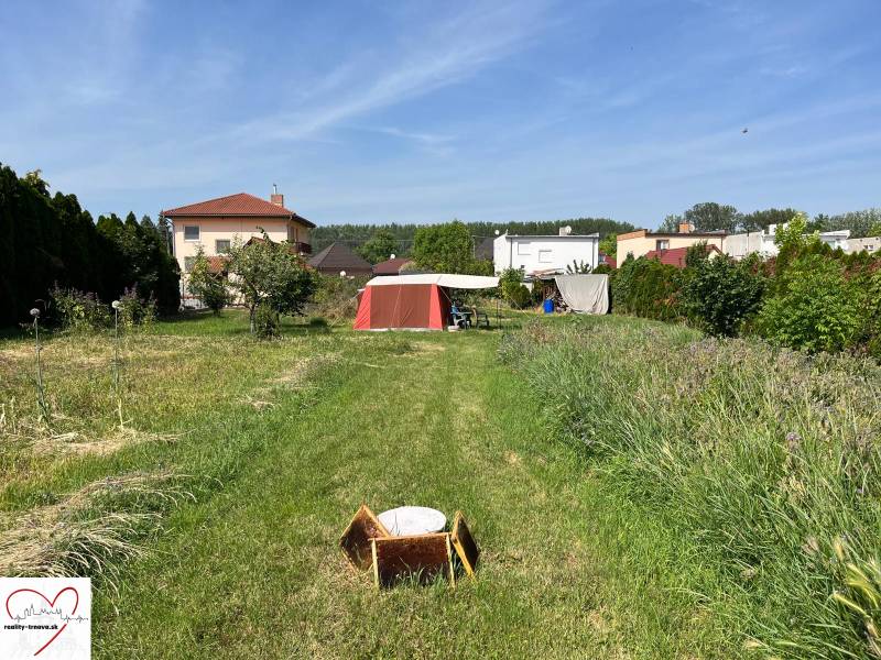 Plots - housing in Dolný Bar with a grassy area, garden, and wooden cottage.