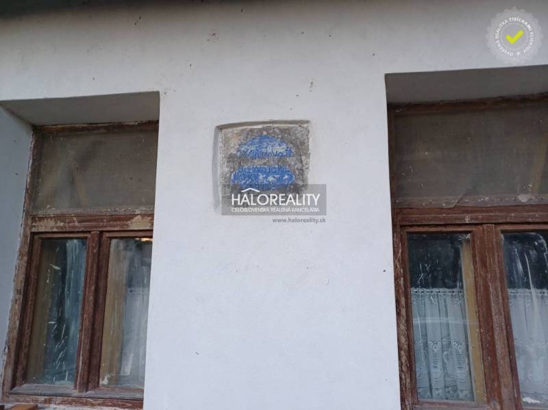 Two neglected windows of a family house in Ladzany with an erosive inscription on the wall.