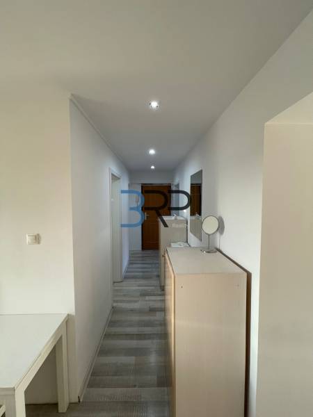 Hallway of a 2-room apartment with white walls and built-in lighting.