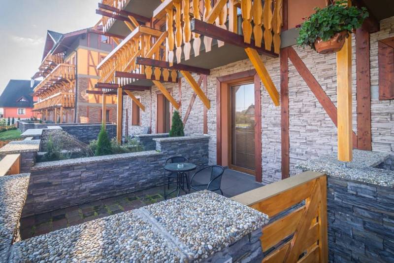 A recreational apartment in Veľká Lomnica with a stone terrace and wooden balconies.