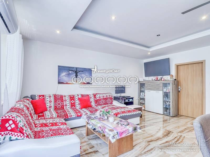 Living room in a 2-room apartment with a colorful sofa and TV, bright interior.
