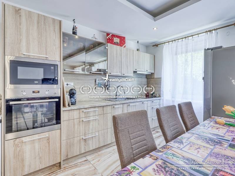A kitchen in a 2-room apartment with wooden cabinets and built-in appliances.