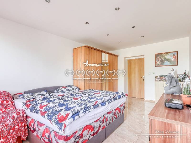 A bedroom in a two-room apartment with a bed, a wardrobe, and decorations on the dresser.