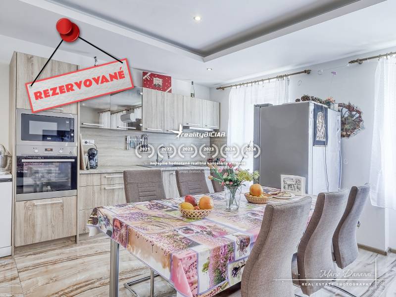 A kitchen in a 2-room apartment with a table, appliances, and a 