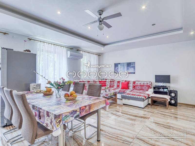 A spacious living room with a dining table in a 2-room apartment, light walls and a patterned sofa.