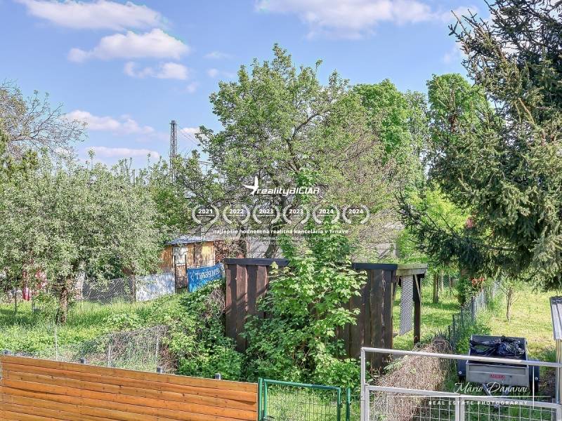 A garden with a wooden shelter surrounded by greenery on Staničná Street in Trnava.