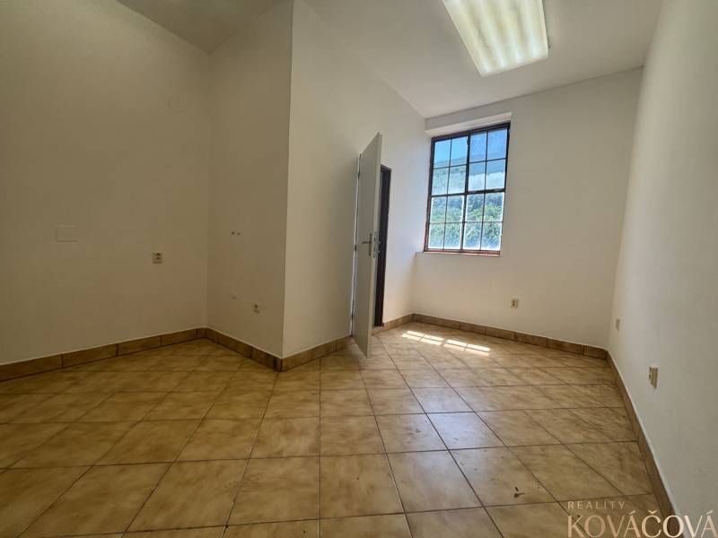 An empty room with a light floor and a large window in a warehouse and hall.