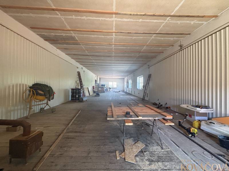 Spacious interior of warehouses and halls with wooden flooring, building materials, and tools.