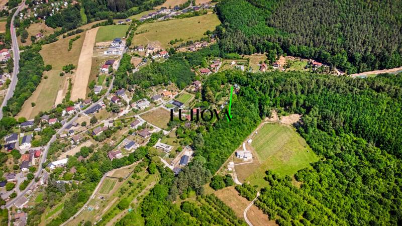 Aerial view of recreational plots surrounded by forests and houses in Púchov, Vieska-Bezdedov.