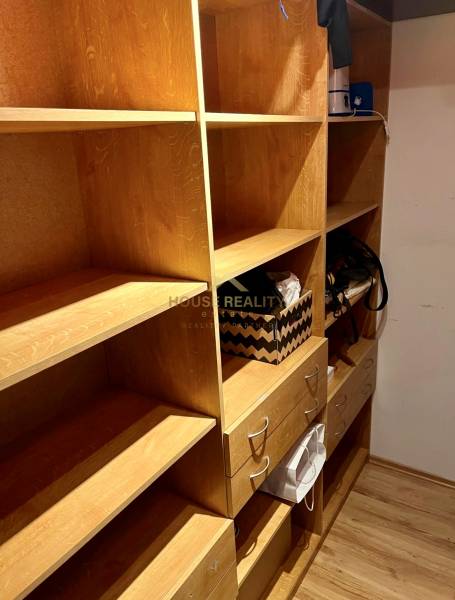 Storage space with wooden shelves and drawers in a 2-room apartment.