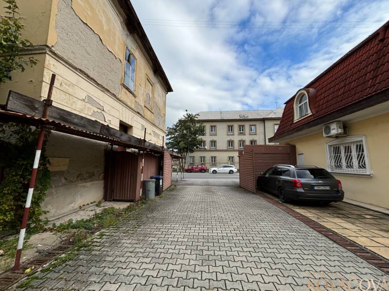 Old buildings and a parked car on M.R. Štefánika in Trenčín, Construction of apartments.