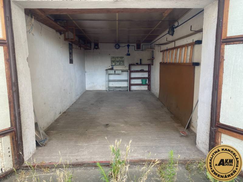 An empty garage in Zvolen with shelves and tools on the wall.
