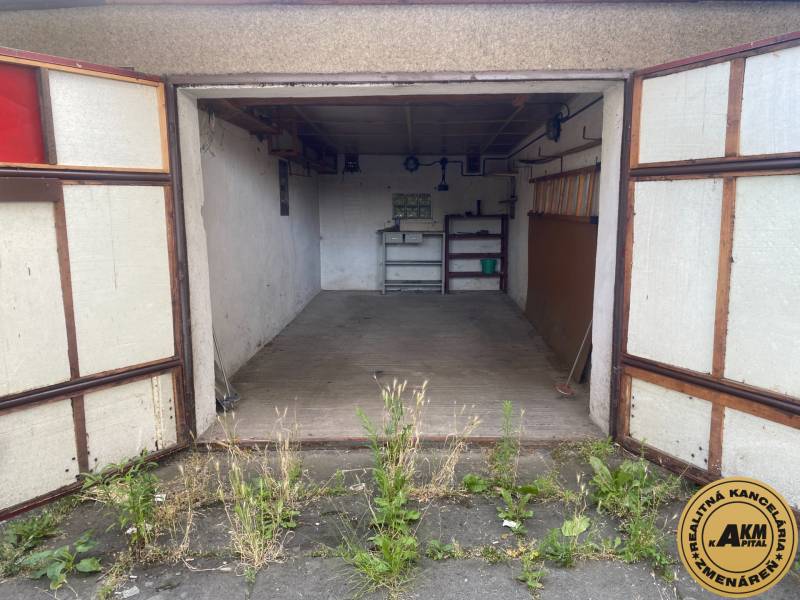 An open garage with an old interior and plants in front of the garage in Zvolen.