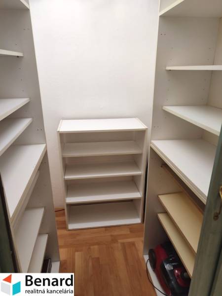 Storage space with a white shelving system in a 2-room apartment.