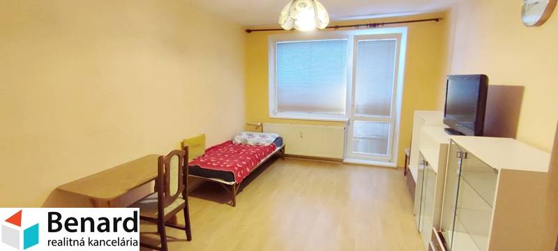 A room in a 2-room apartment with a bed, a table, a television, and a wardrobe.