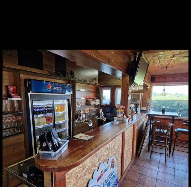 Wooden interior of gastro spaces with a bar, refrigerator, and television.