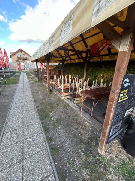 Covered terrace of a gastro space with enclosed seating on Devínske jazero street, Bratislava.